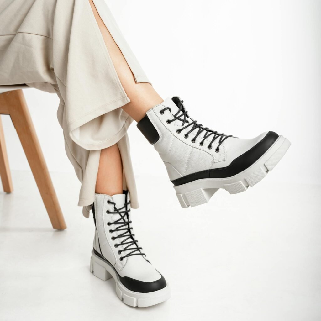 Trendy white lace-up boots with black detailing, perfect for contemporary fashion lovers.